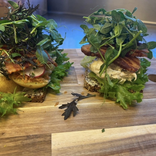 Kreativt smørrebrød med kartoffel, bacon og friske ærteskud – nydes hos Svogers Spiseri i Sæby, ikke langt fra Frederikshavn og Aalborg.